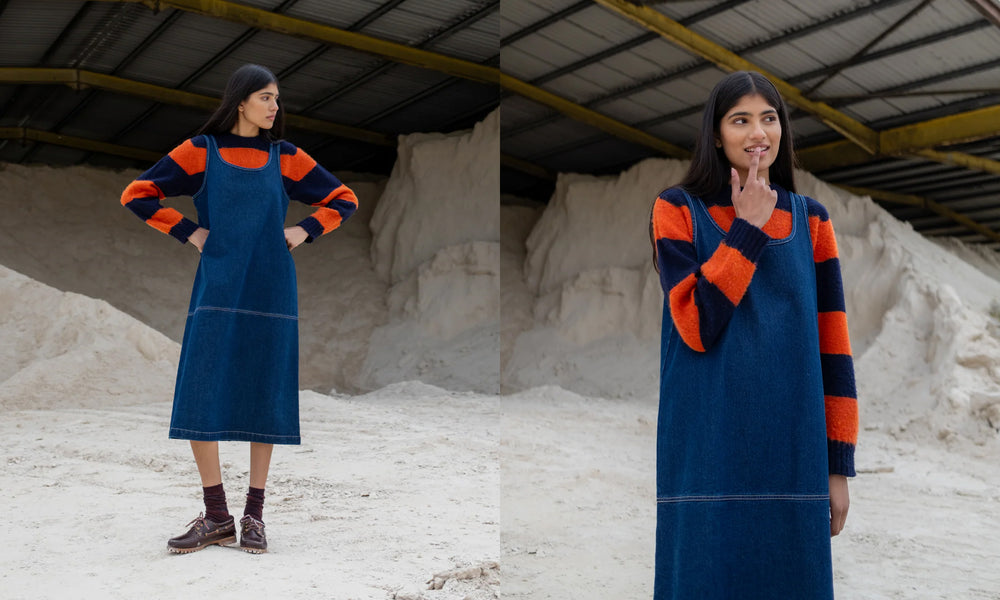 Woman wearing a Folk blue Slip Dress with orange and navy accents in an industrial setting.